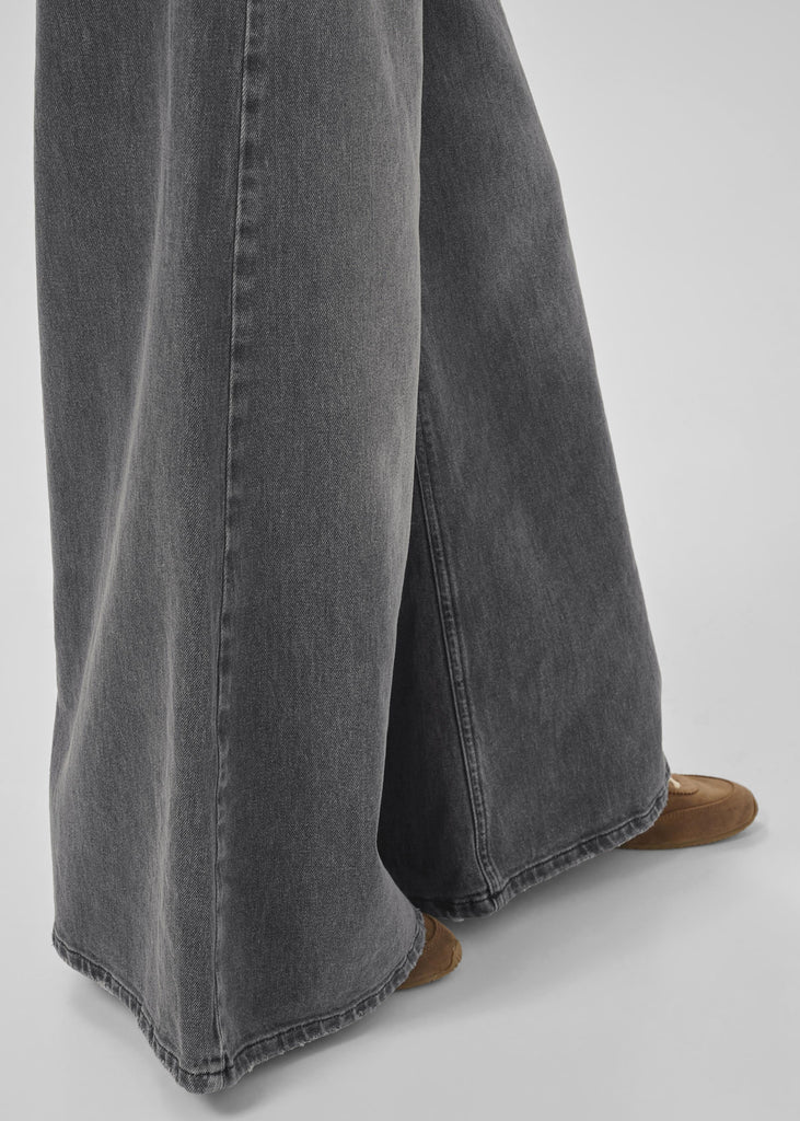 Gray wide-leg jeans worn by a person on a white background
