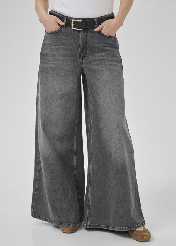 Person wearing wide-leg gray jeans on a plain background