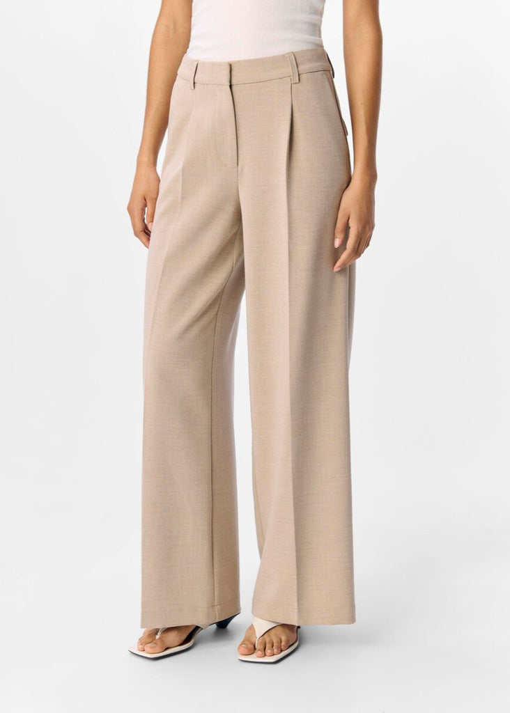 Beige wide-leg pants worn by a person on a white background