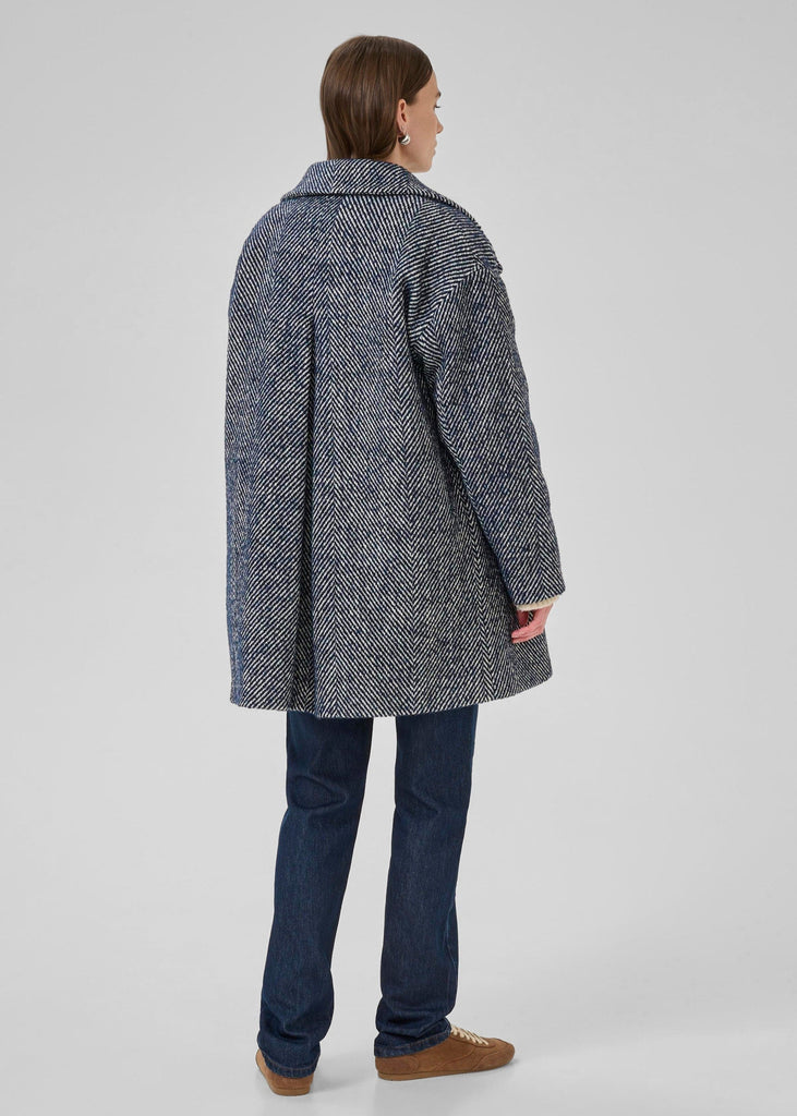 Person wearing a gray textured coat on a white background