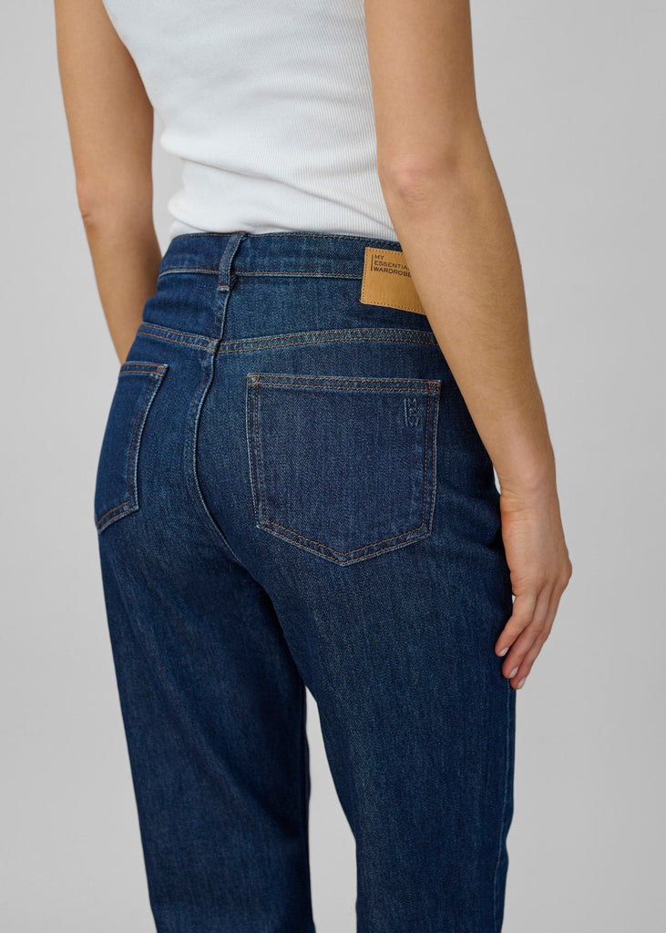 Person wearing blue jeans with a white background