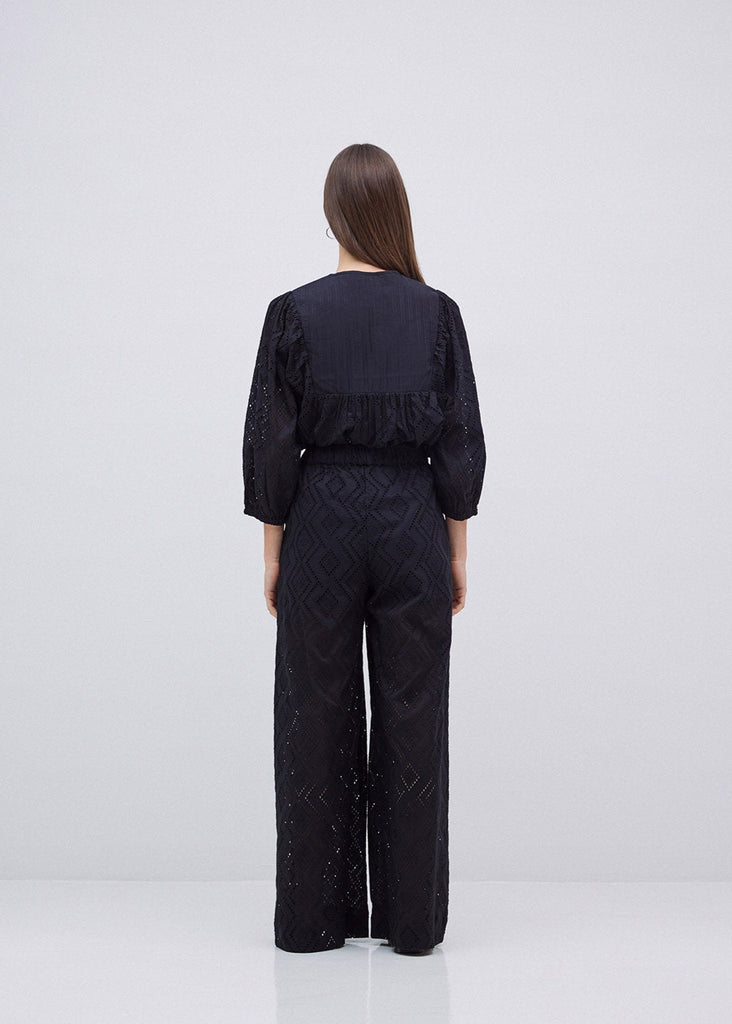 Woman wearing a black textured outfit on a white background