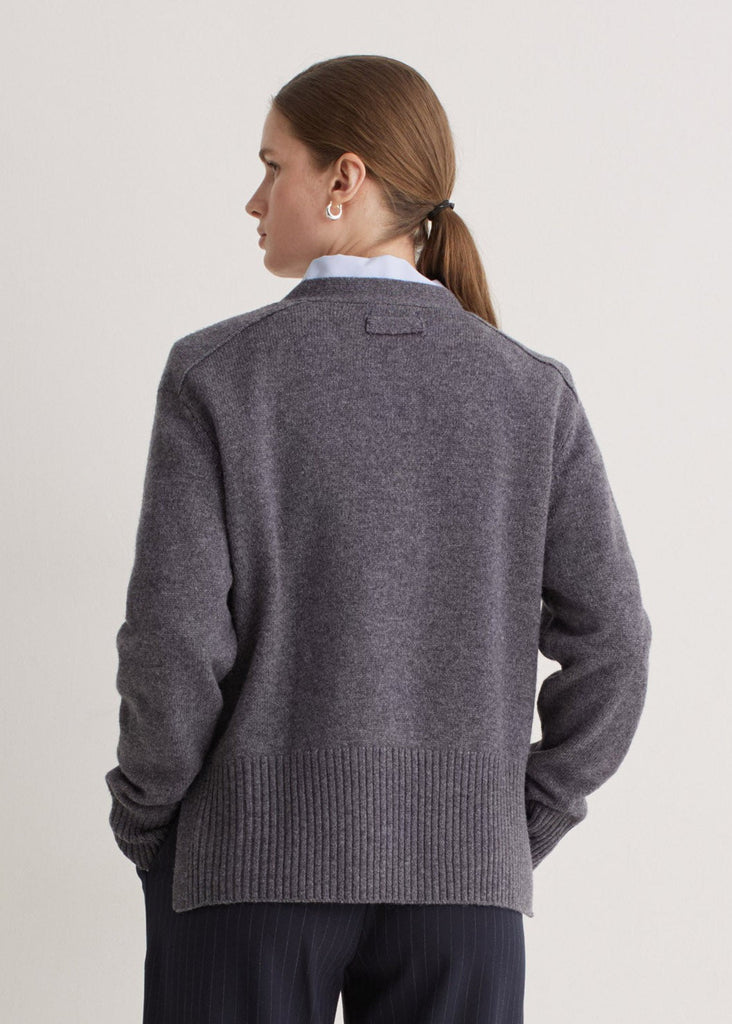 Woman wearing a gray sweater on a light gray background