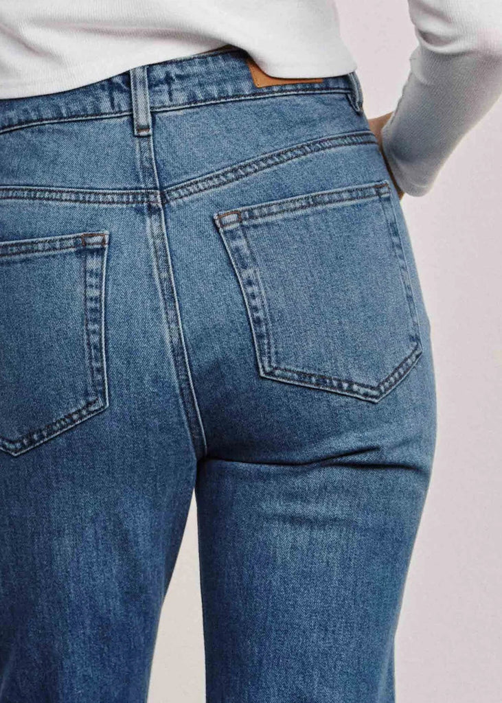 Close-up of blue jeans on a plain background
