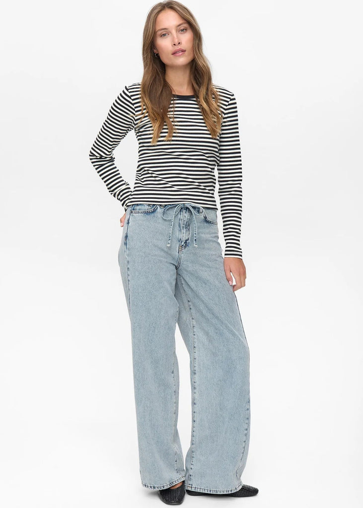 Woman wearing a striped shirt and light blue jeans on a white background