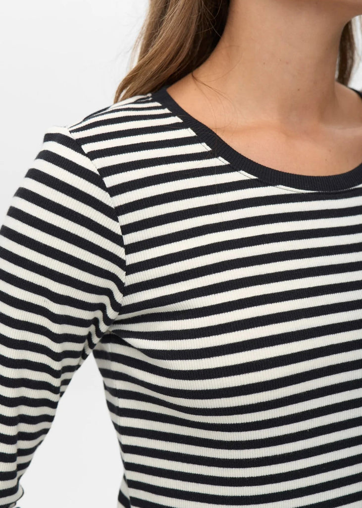 Close-up of a person wearing a black and white striped long-sleeve shirt.