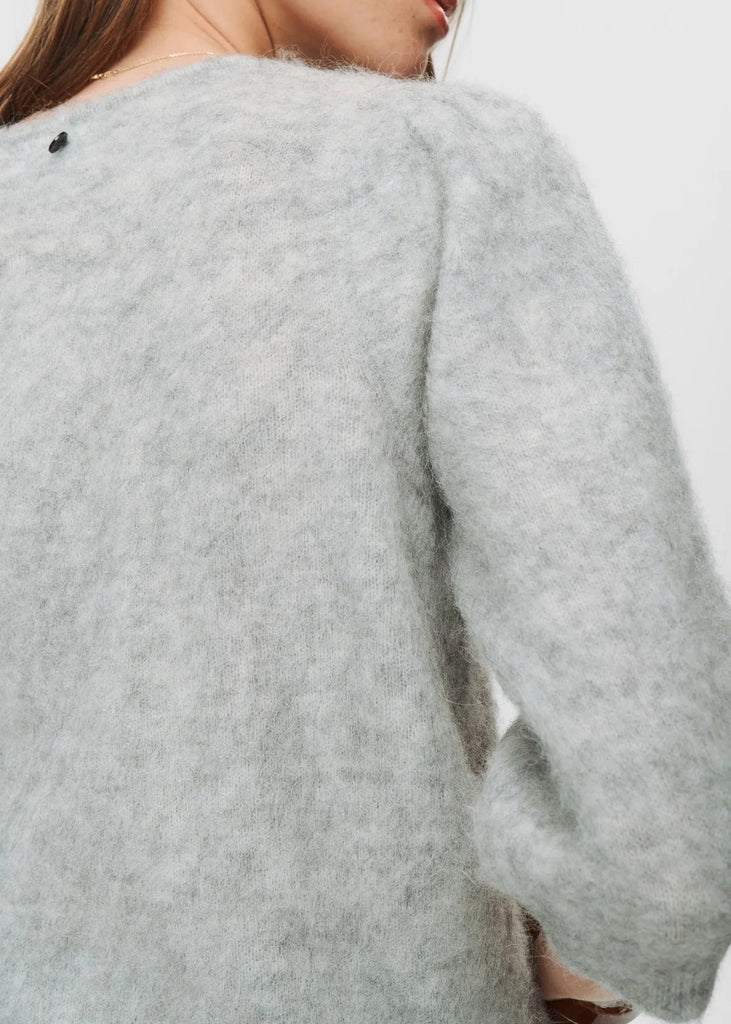 Gray sweater worn by a person on a light gray background