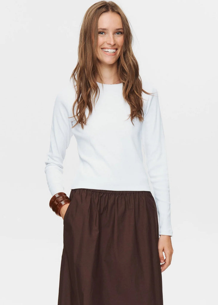 Woman wearing a white top and brown skirt on a white background