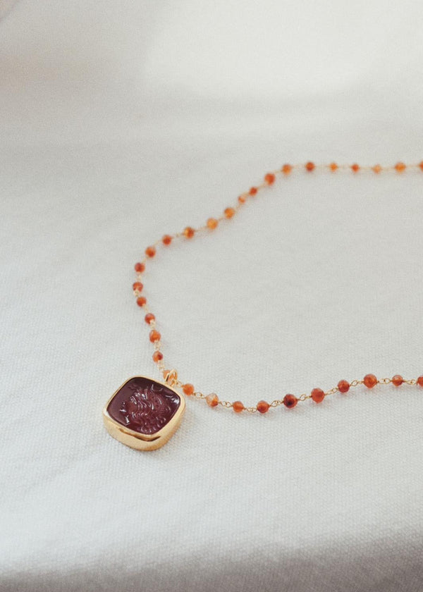 Necklace with a red gemstone pendant on a light background