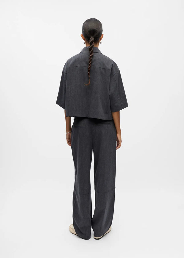 Person wearing a dark gray outfit on a white background