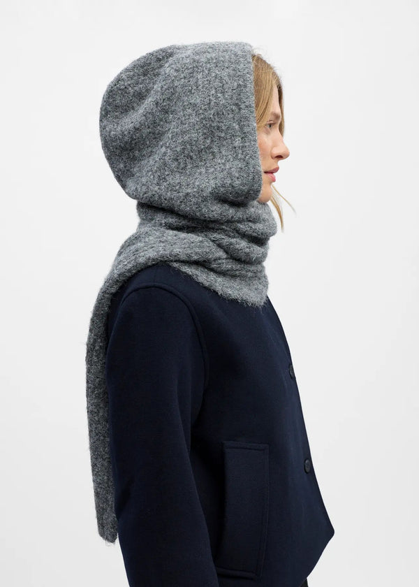 Person wearing a gray hooded scarf and navy coat on a white background