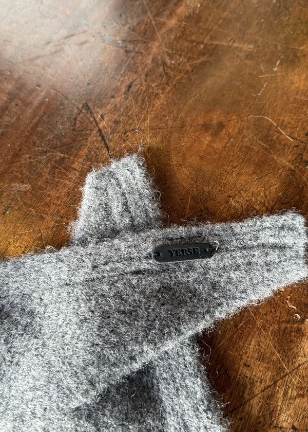 Gray felt object with 'Versa' branding on a wooden surface