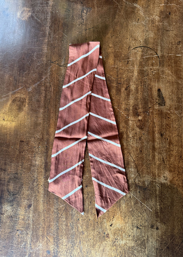 Pink fabric with white stripes on a wooden surface