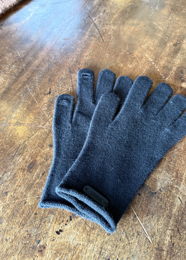 Pair of dark blue gloves on a wooden surface