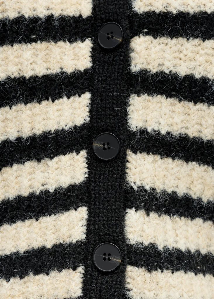 Close-up of a black and white striped knitted cardigan with buttons.