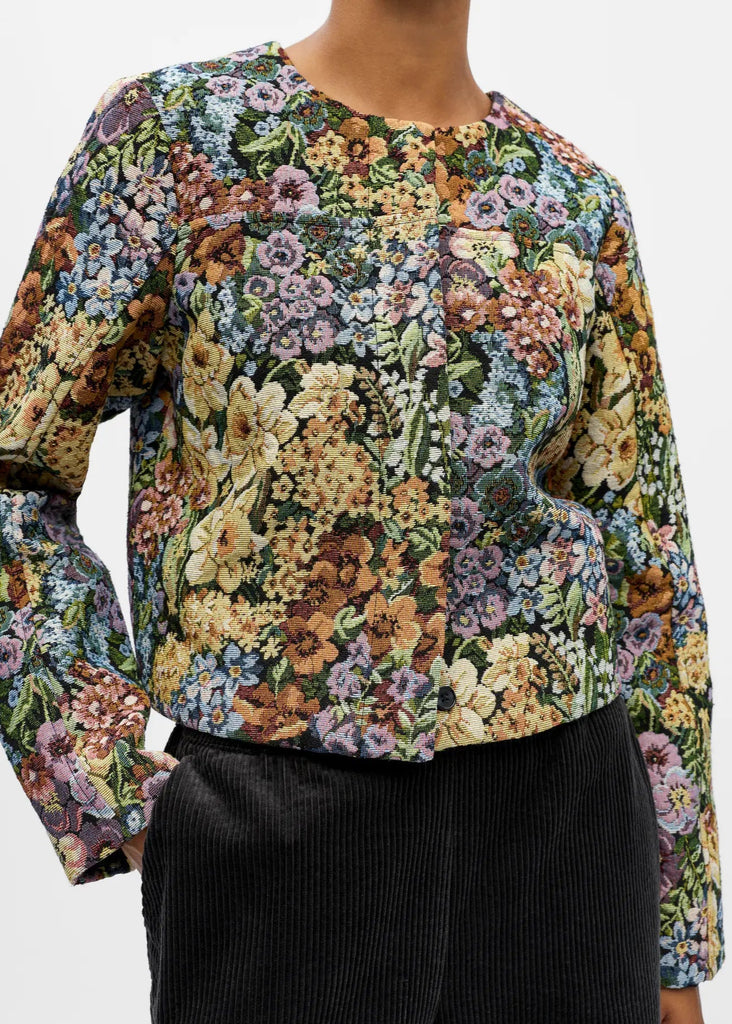 Floral patterned top worn by a person on a white background