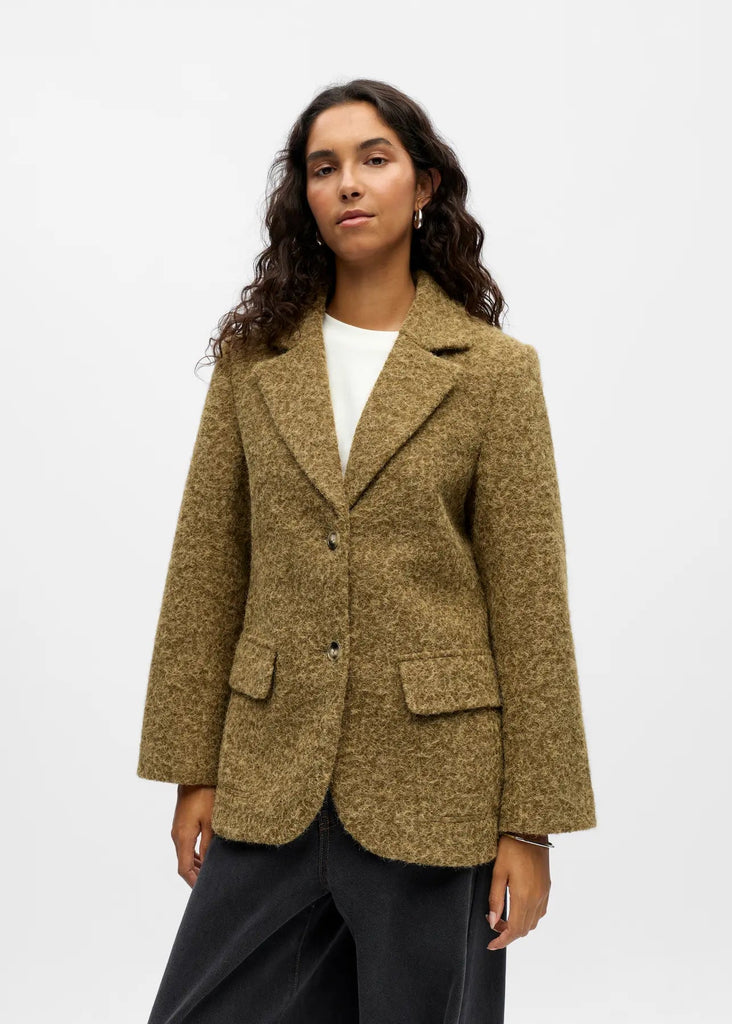 Woman wearing a brown blazer on a white background