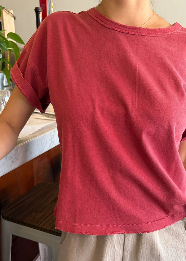 Person wearing a red t-shirt with a blurred background