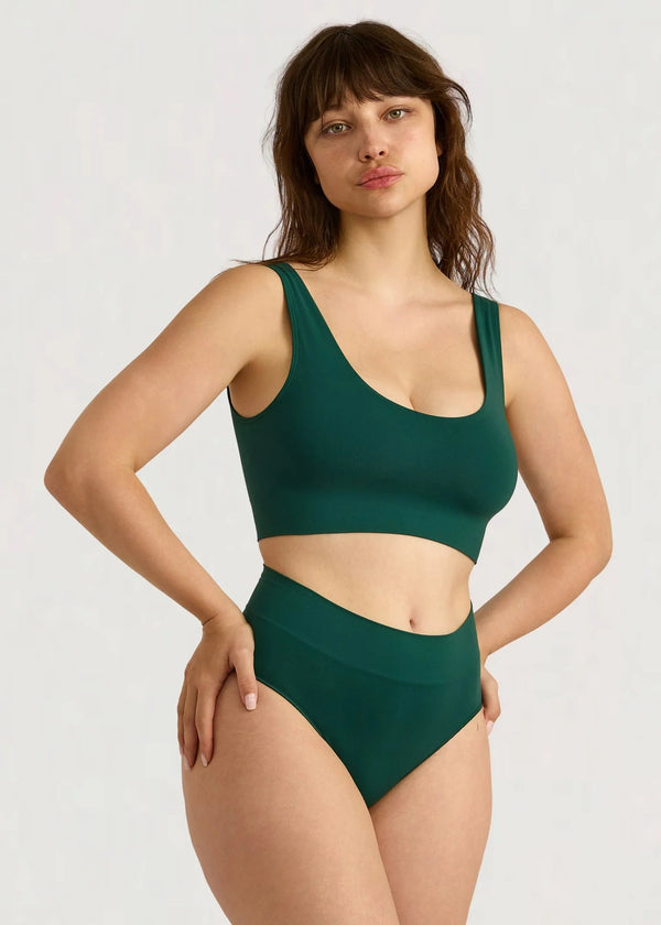 Woman wearing a green bikini set on a white background