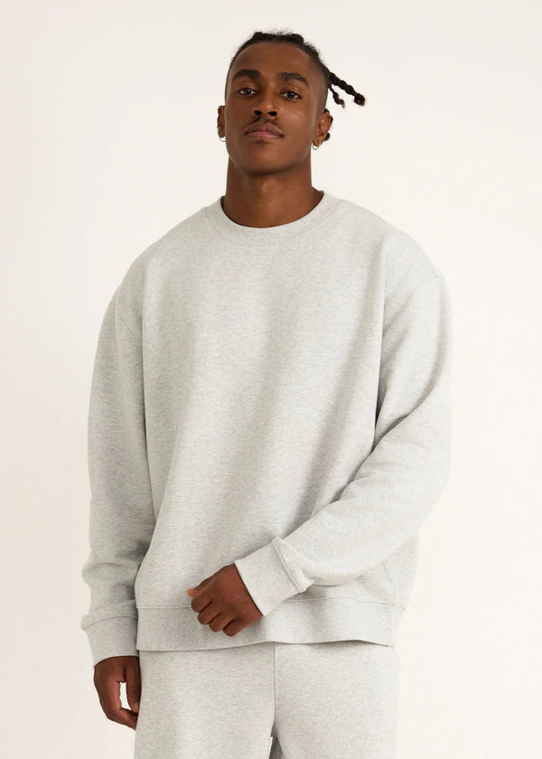 Person wearing a gray sweatshirt and pants on a plain background