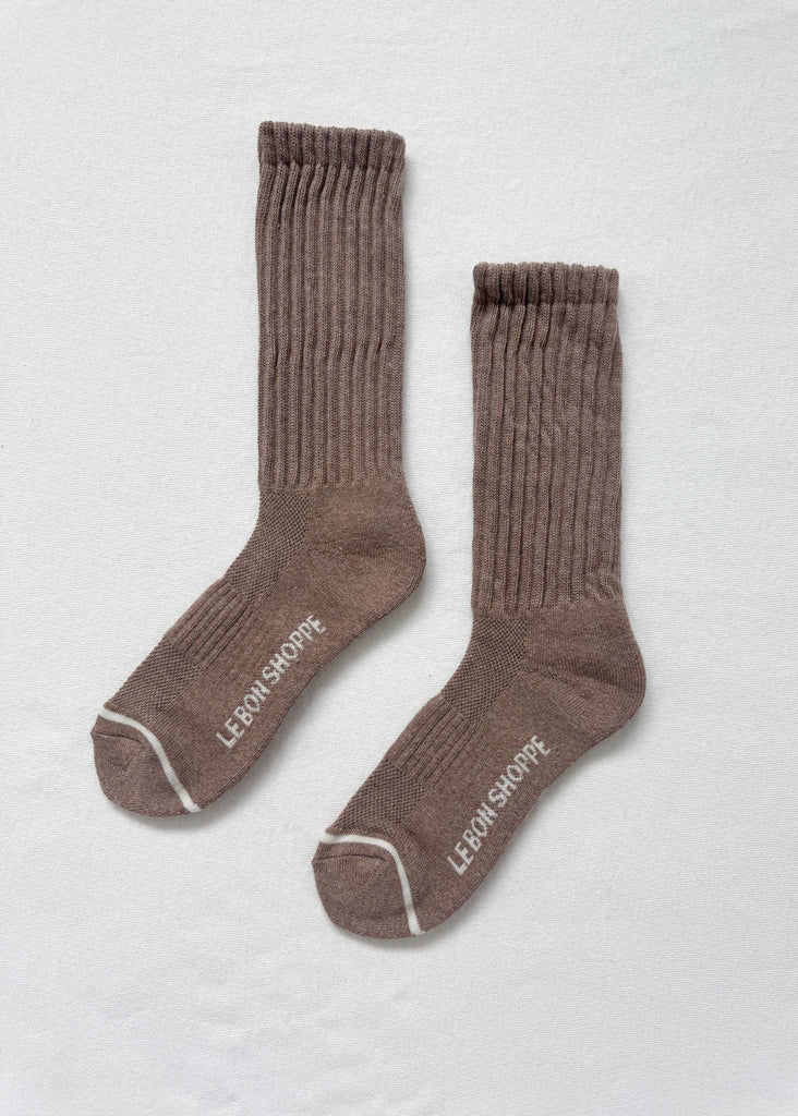 Pair of brown socks with white trim on a light gray background