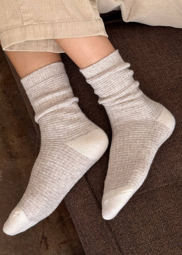 White socks worn on a person's feet with a neutral background