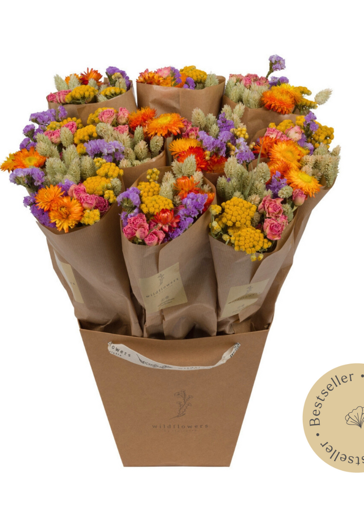 Bouquet of colorful flowers wrapped in brown paper with a Bestseller label on a white background