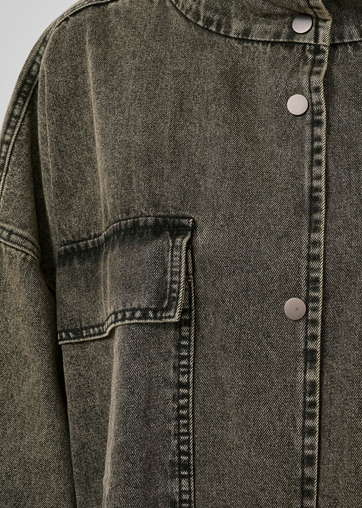 Close-up of a dark denim jacket with button details