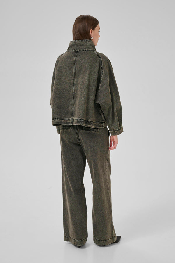 Person wearing a textured jacket and pants on a light gray background