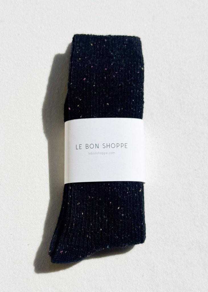 Pair of black socks with a white label on a light gray background