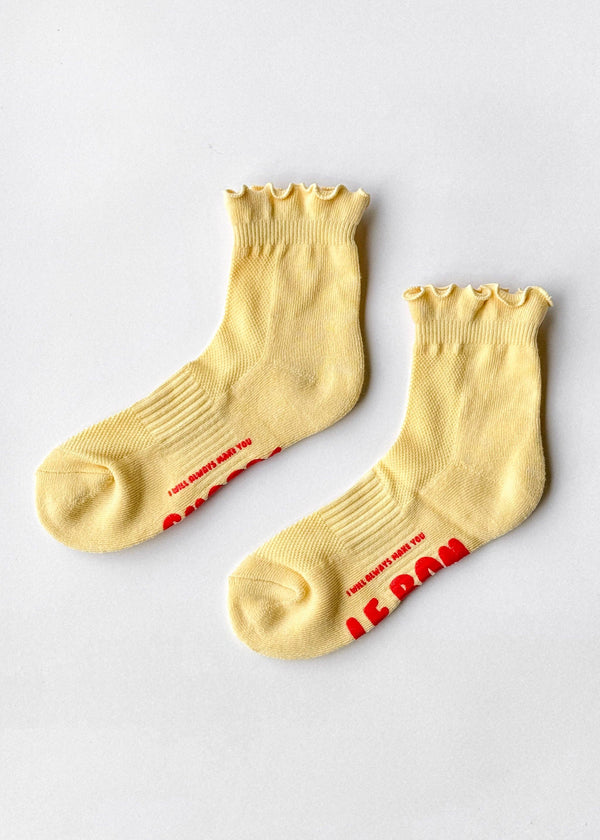 Pair of yellow socks with red text on a light gray background
