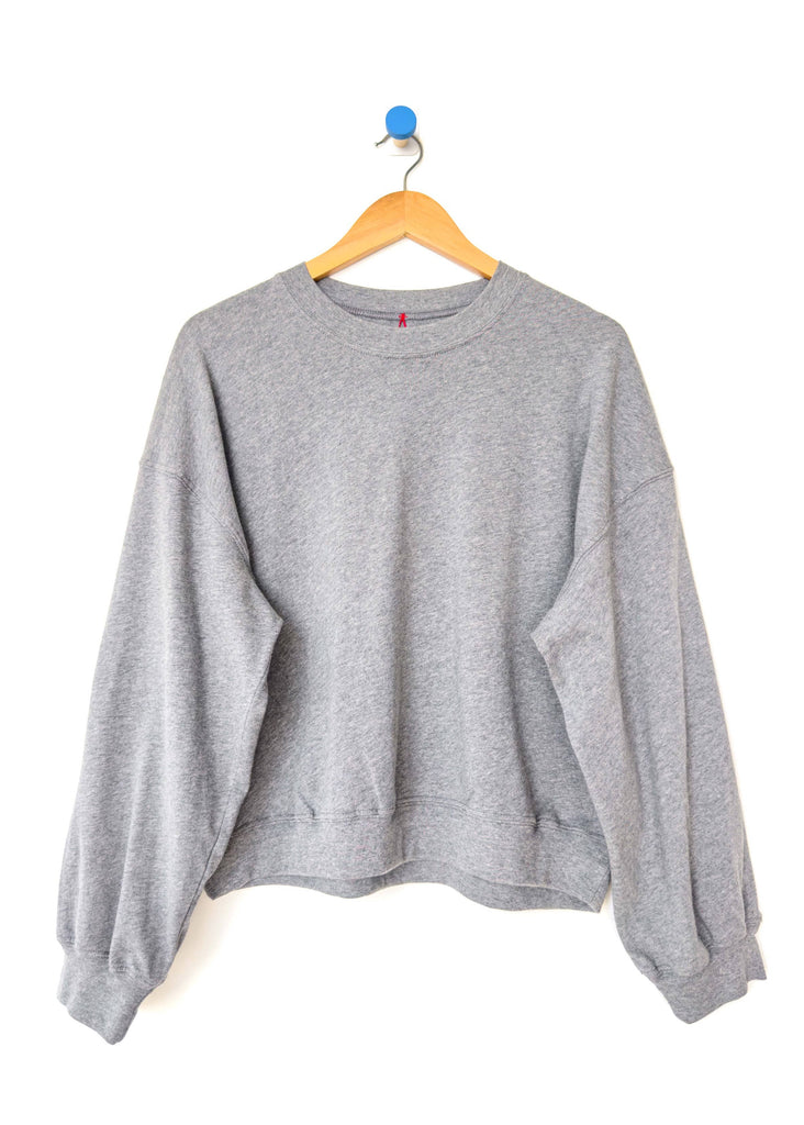 Gray sweatshirt on a hanger against a white background