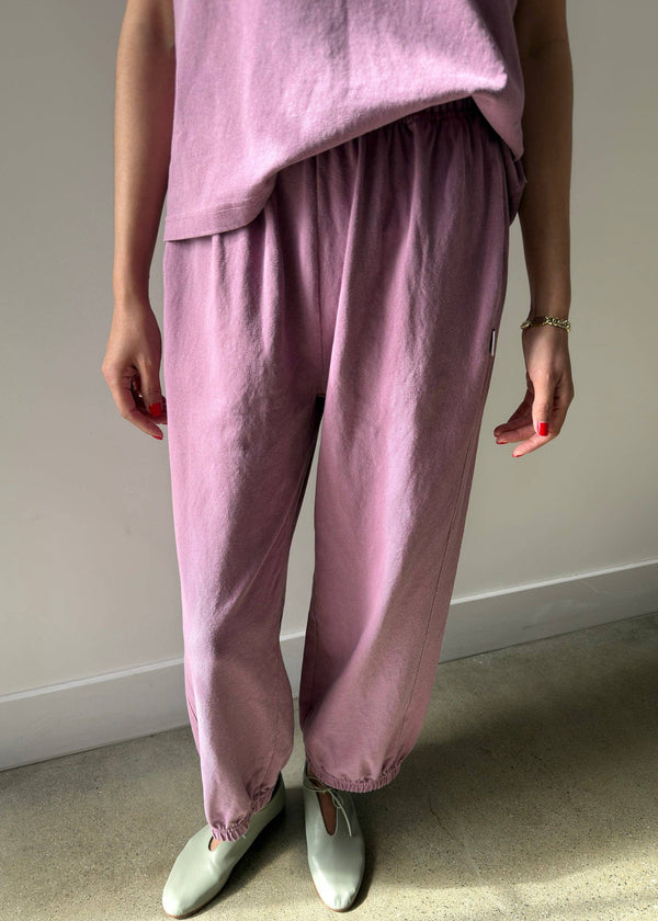 Person wearing a pink outfit with matching pants and top against a neutral background