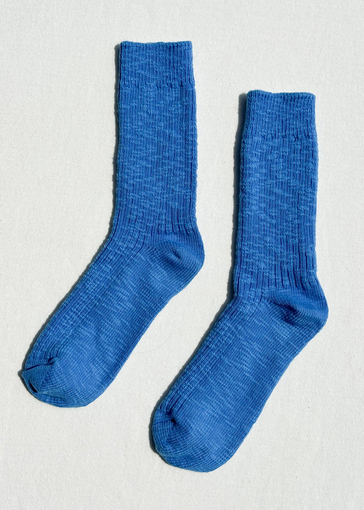 Pair of blue socks on a light gray background