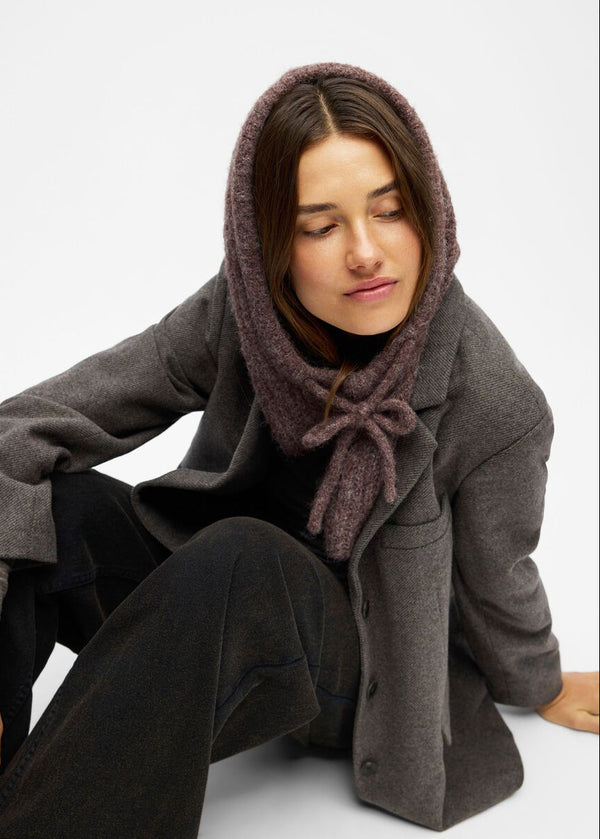 Woman wearing a gray coat and brown hooded scarf on a white background