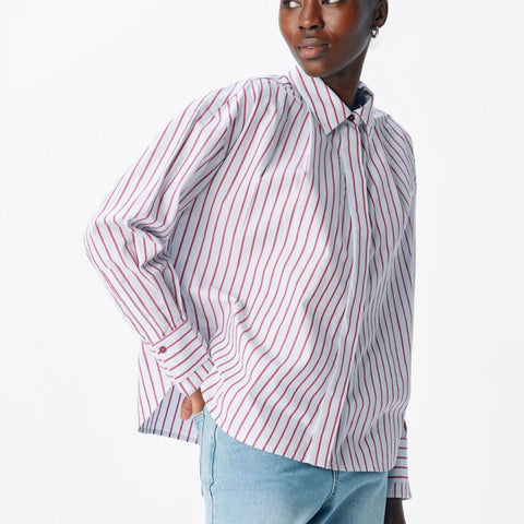Woman wearing a striped shirt and light blue jeans on a white background