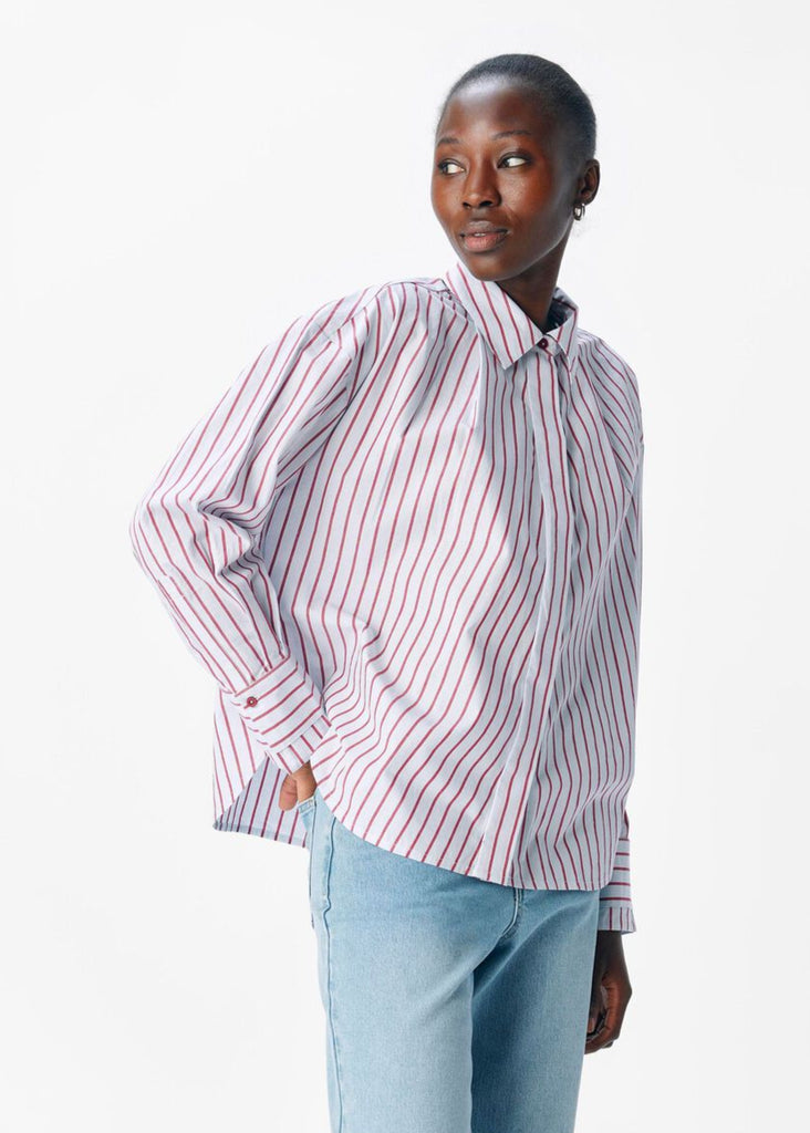 Woman wearing a striped shirt and light blue jeans on a white background