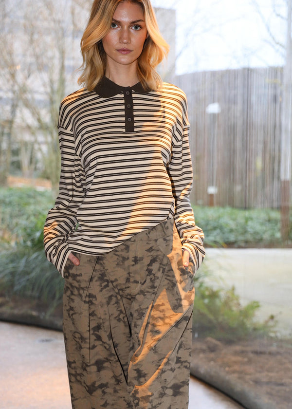 Woman wearing a striped shirt and patterned pants outdoors
