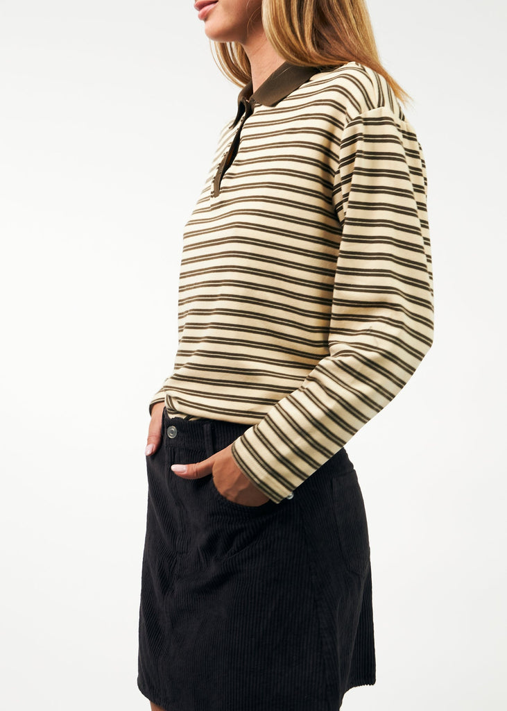 Person wearing a striped long-sleeve shirt and black skirt on a white background