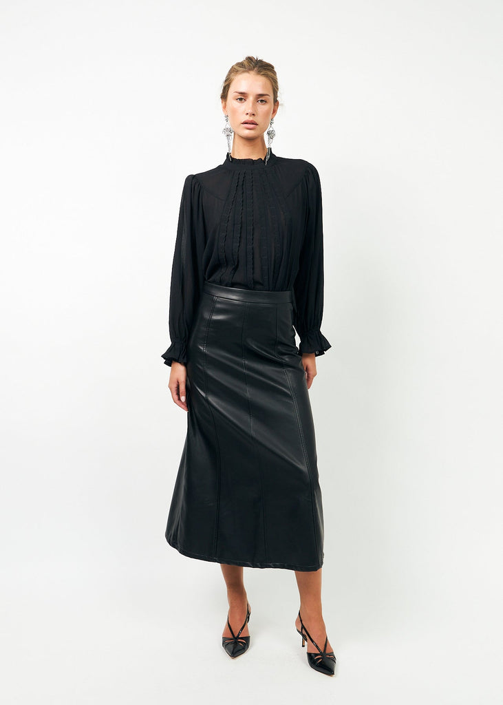 Woman wearing a black blouse and black leather skirt on a white background