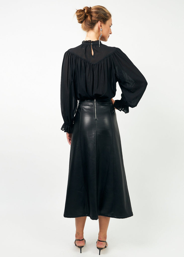 Woman wearing a black blouse and black leather skirt on a white background
