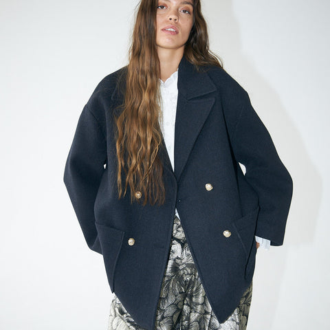 Person wearing a dark blue coat with a white background