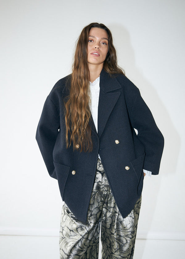 Person wearing a dark blue coat with a white background