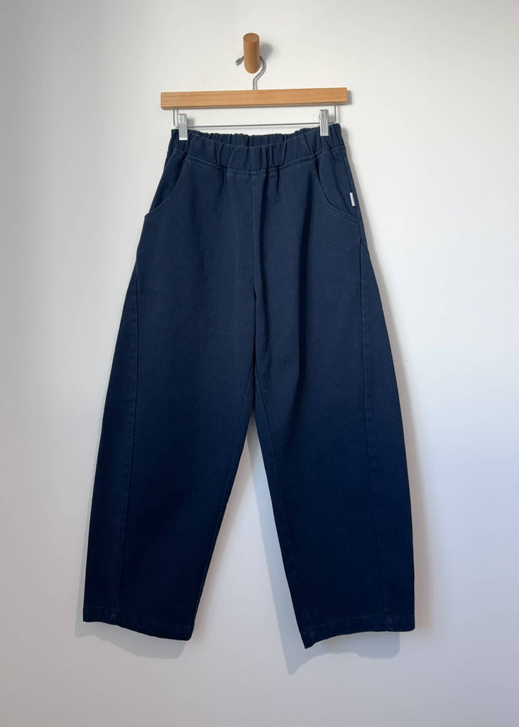 Navy blue pants on a hanger against a white background