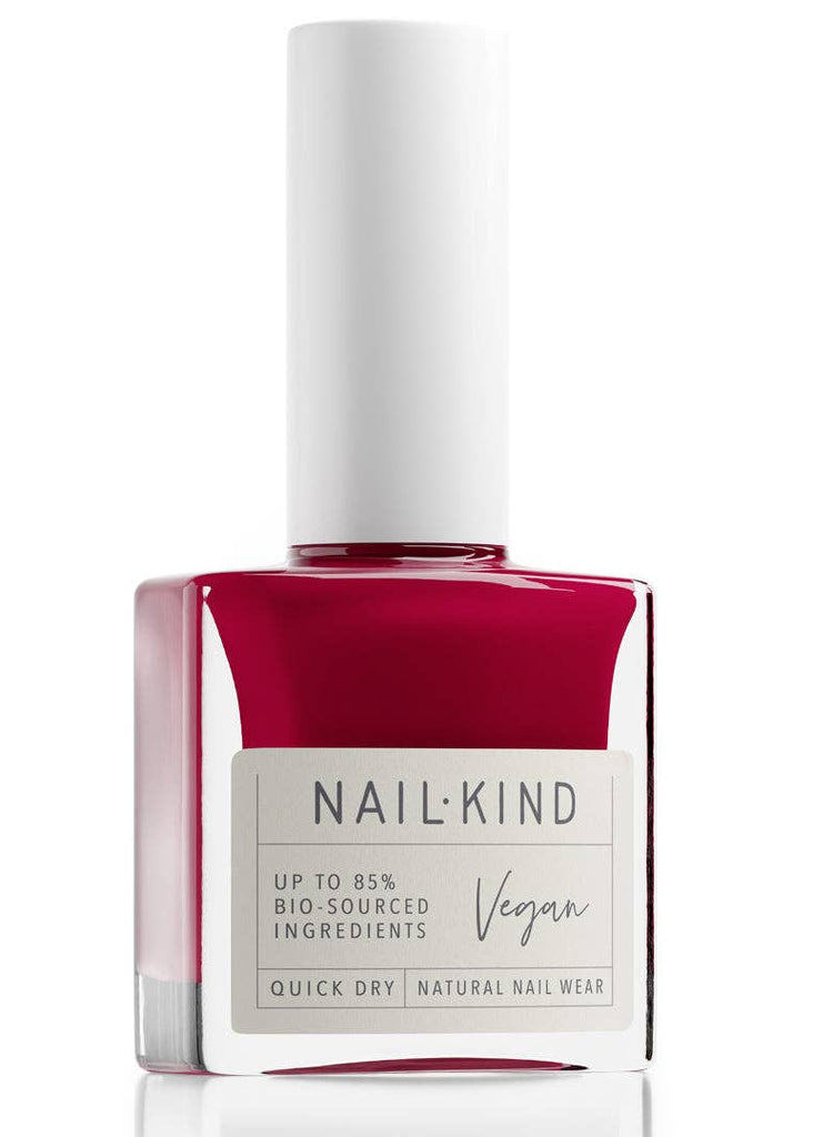 Red nail polish bottle with white cap on a white background