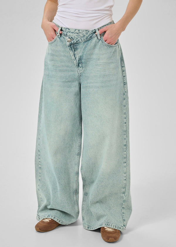 Light blue wide-leg jeans worn by a person on a white background