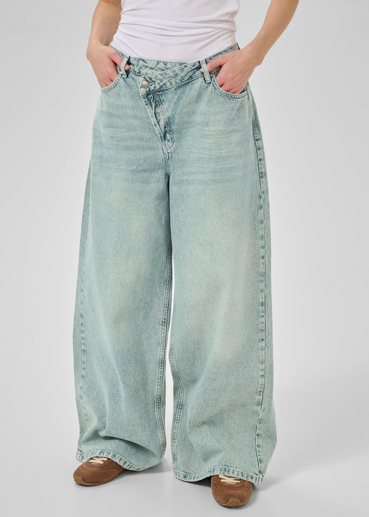 Light blue wide-leg jeans worn by a person on a white background