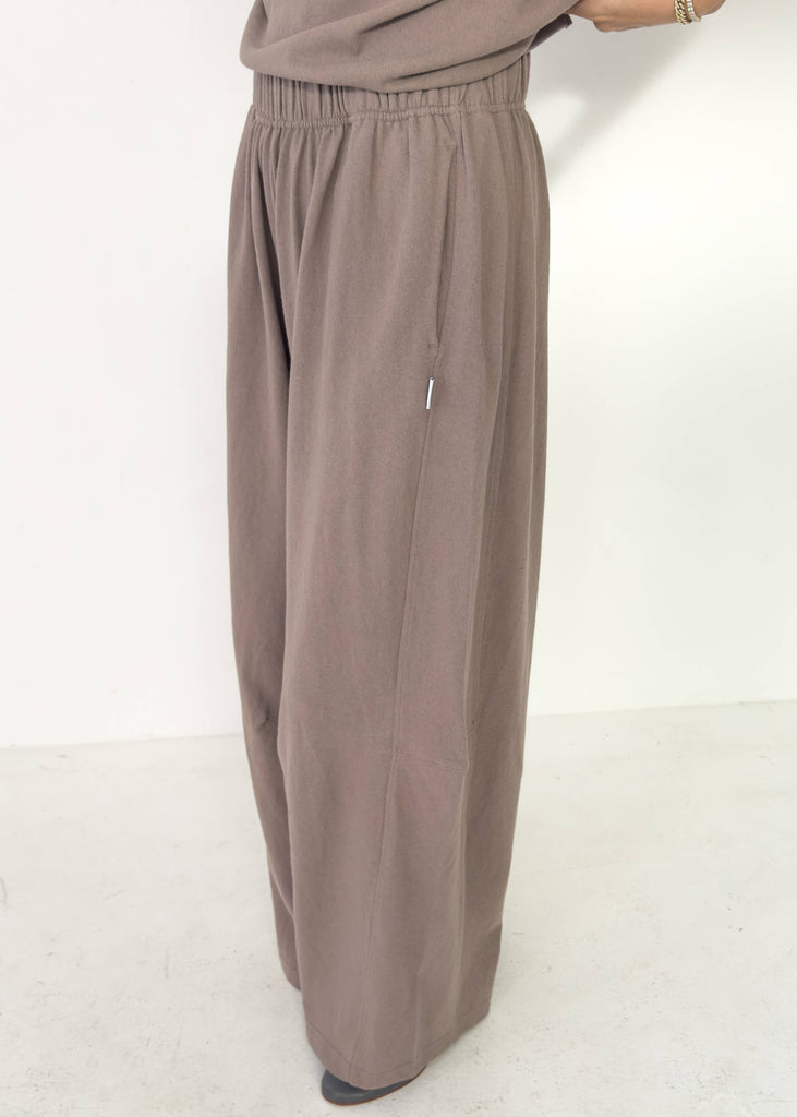 Brown wide-leg pants worn by a person on a white background