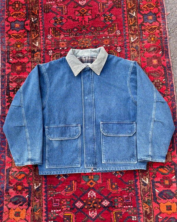 Blue denim jacket with plaid collar on a red patterned rug