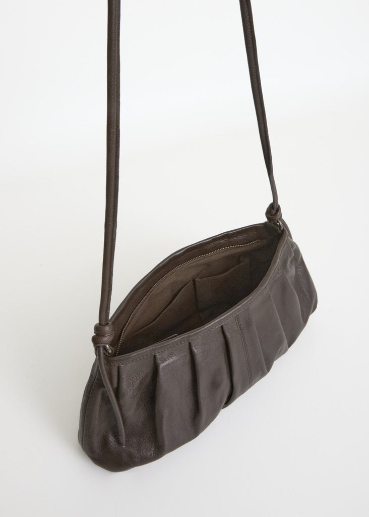 Brown leather handbag with a strap on a white background
